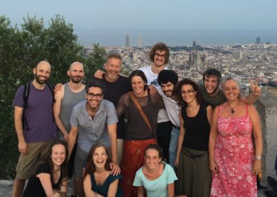 a group of people are standing in front of a city panorama with their arms around each other, smiling